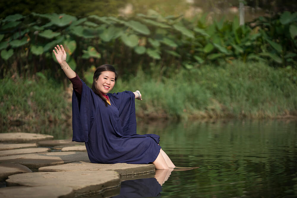 graduate girl sitting in the river