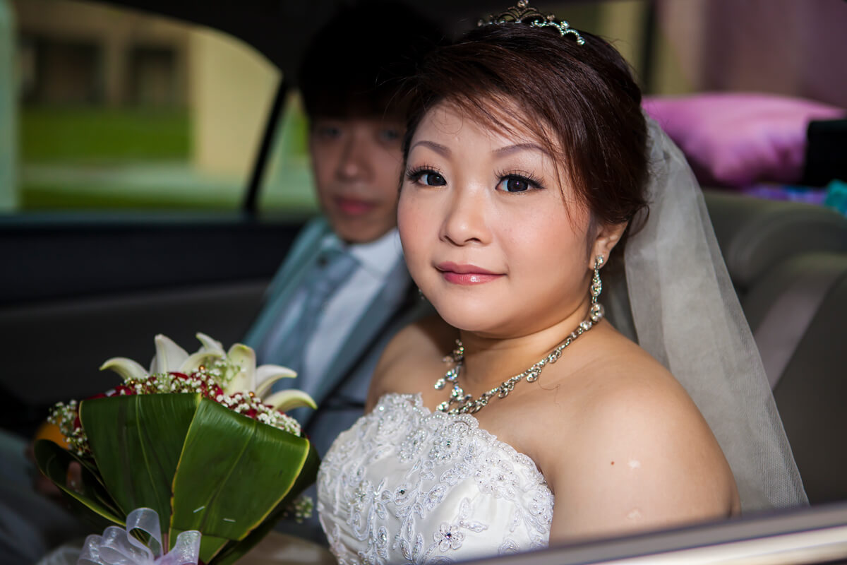 wedding couple with flowers in car